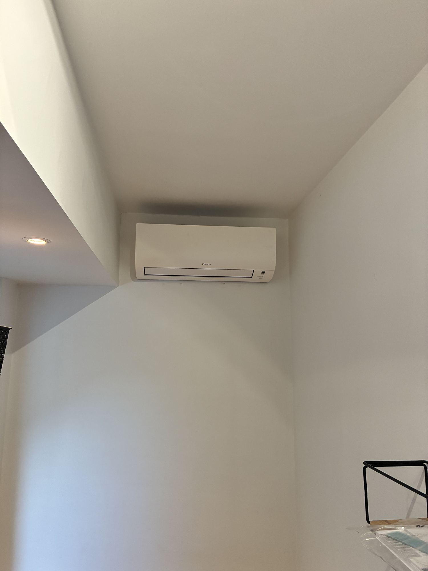 Airco-installatie Melis Cooling, wandunit hoog aan een witte muur